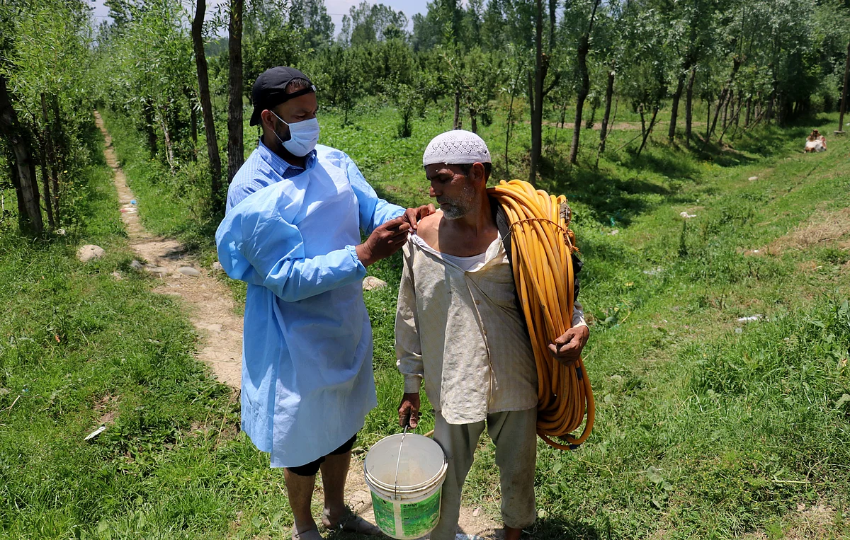 A health worker administering COVID-19 vaccine dose to an elderly in Kashmir.