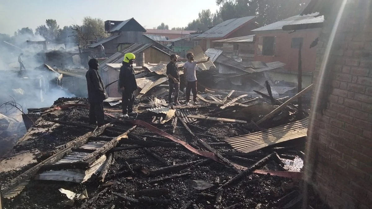 Firemen along with locals inspect a house gutted in blaze in Parimpora area on Srinagar outskirts on Thursday October 7, 2021.