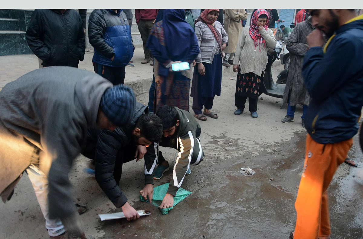 Men clean blood off the road after a brief shootout, on Wednesday 24 Nov 2021.