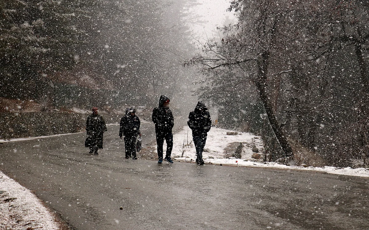 People walking amid snowfall in Gulmarg area of north Kashmir's Baramulla, on Thursday 23 December 2021.