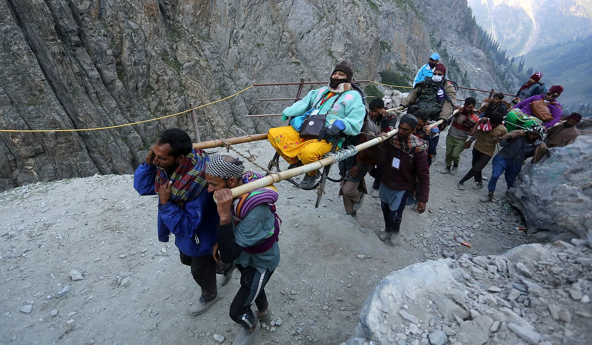Labourers carry a Hindu devotee as along the Baltal route towards Amarnath cave, on Thursday 30 June 2022.