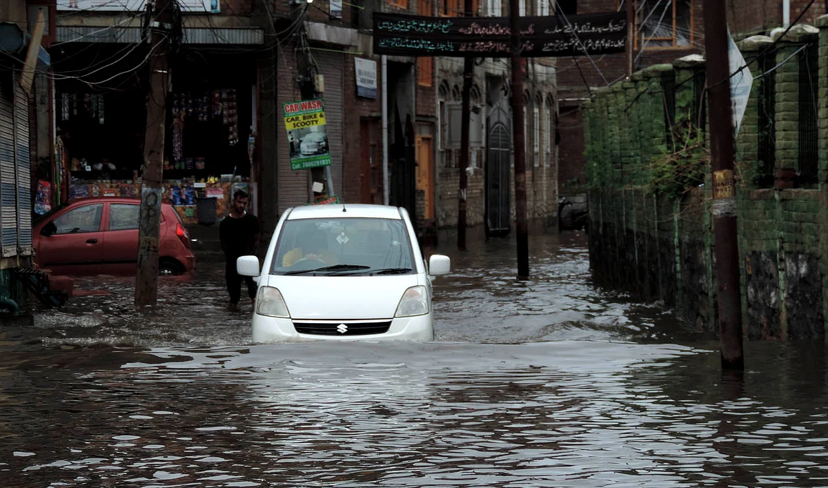 A vehicle moves through a waterlogged road in Srinagar, Thursday, 28 July 2022.