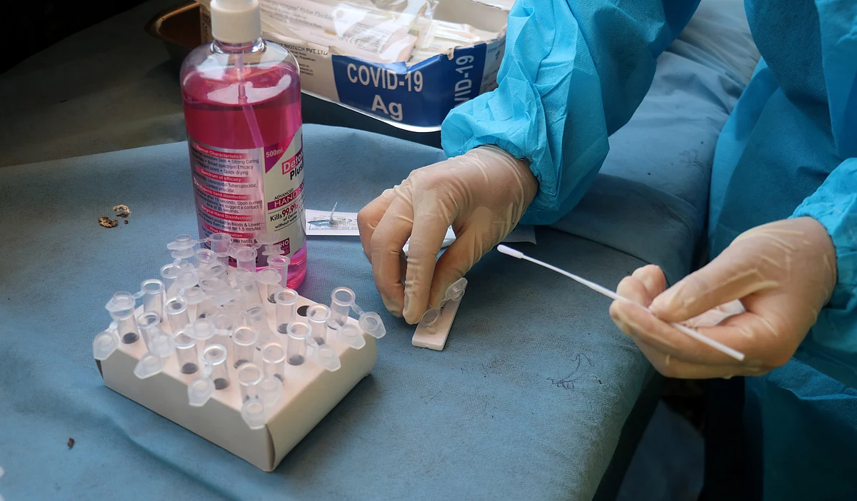 A health worker sorts a swab sample for COVID-19 testing in Kashmir.