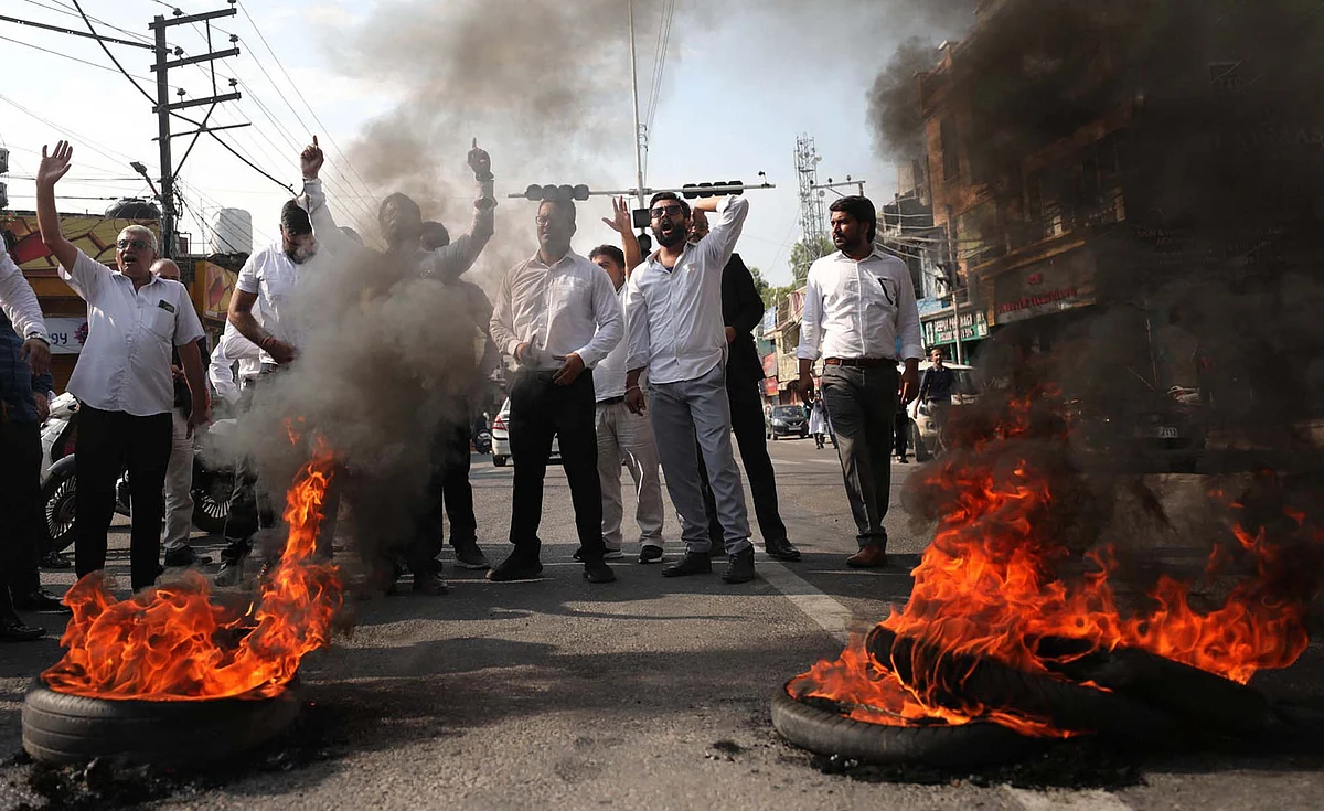 Members of Bar Association sloganeering even as smoke rises from burnt tires in Jammu.