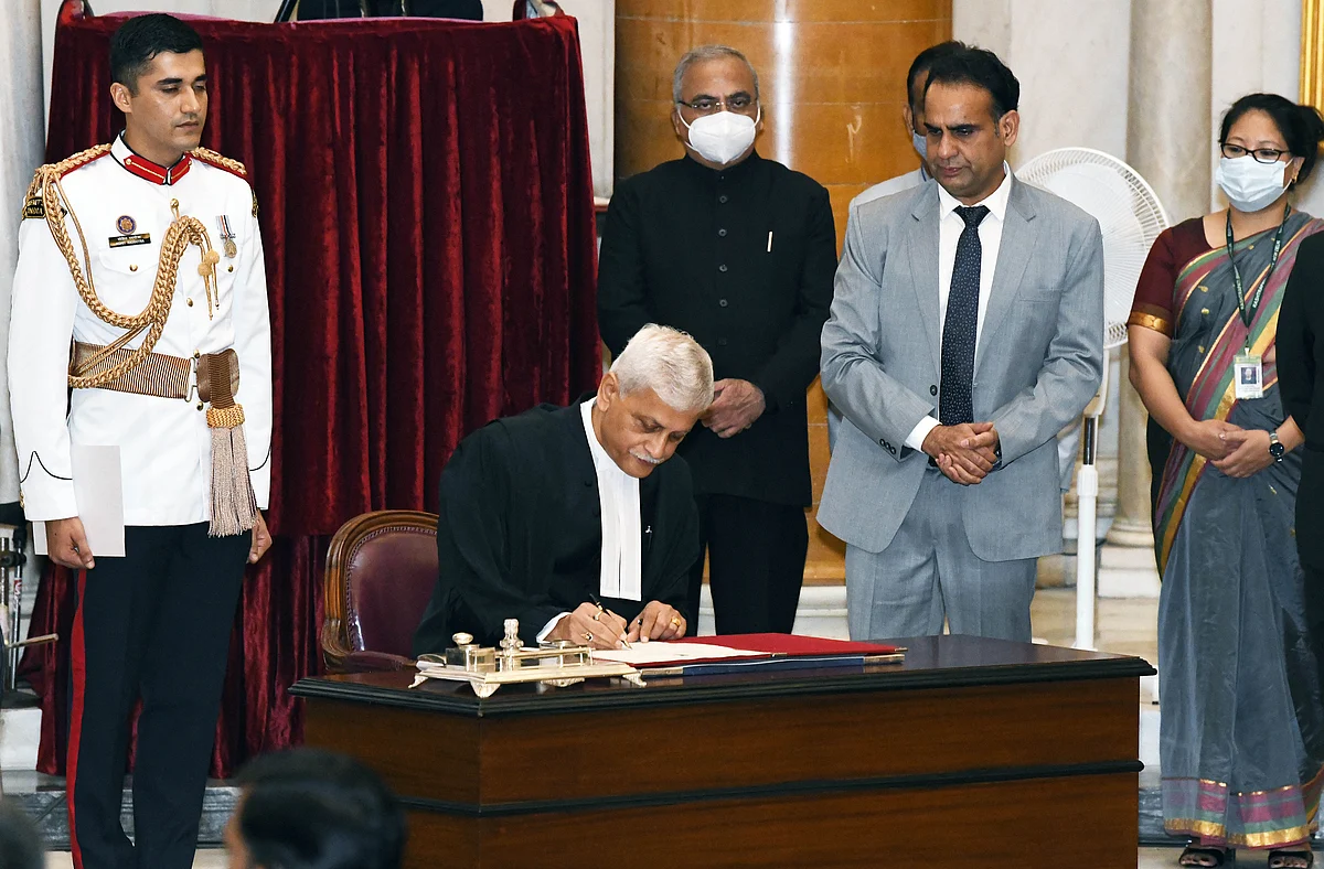 Justice Uday Umesh Lalit signs a register after taking oath as the 49th Chief Justice of India, at Rashtrapati Bhavan, in New Delhi on Saturday.