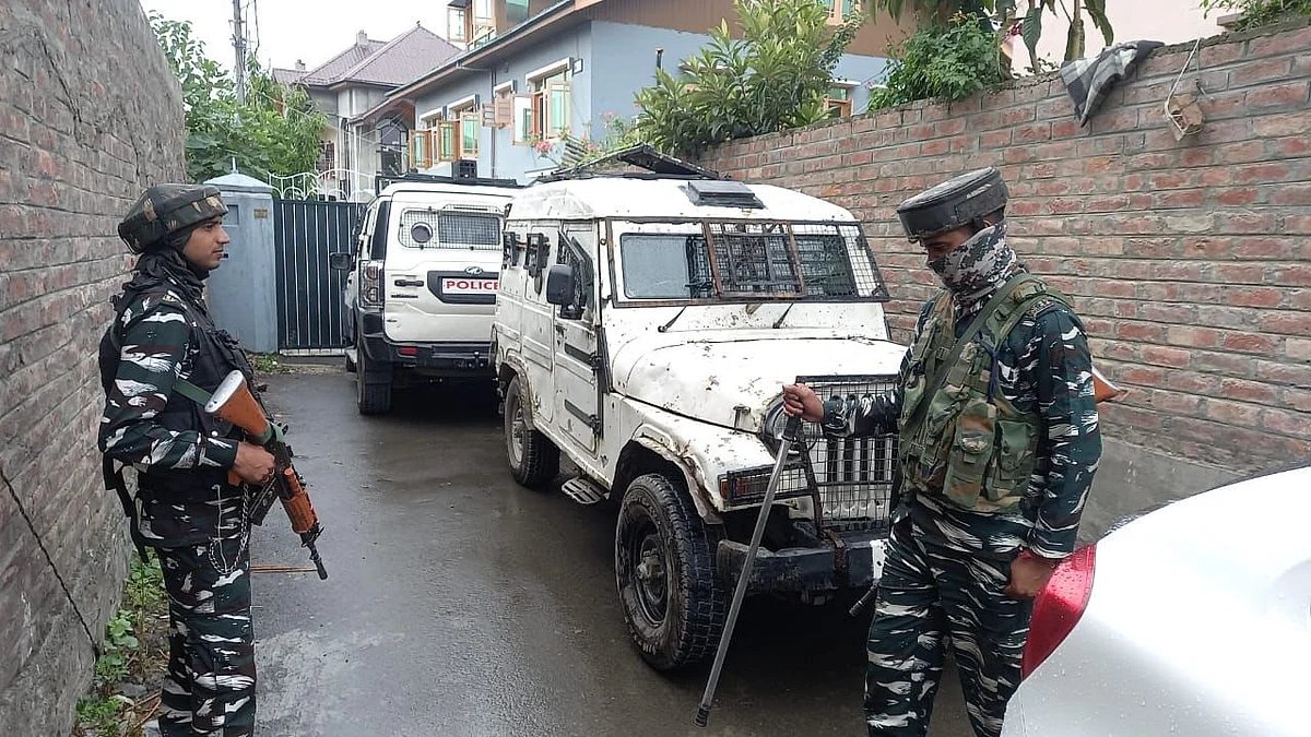 Security forces stand outside as searches are being conducted at Mian Qayoom's residence.