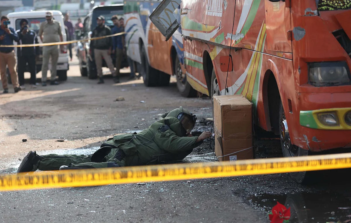 A bomb-disposal man inspects the site where at Udhampur Bus Stand in Jammu after twin explosions took place there on Thursday.