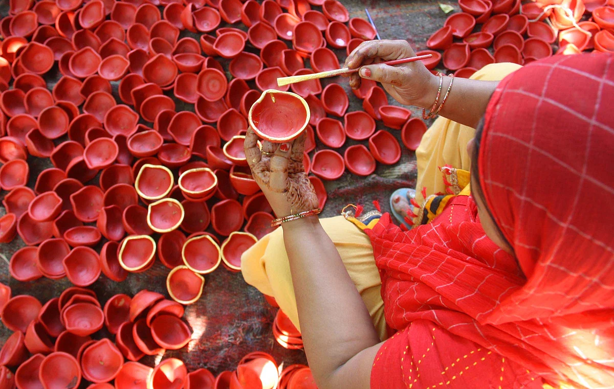 A woman prepares earthen oil-lamps ahead of the Hindu festival Deepawali, On 18th Oct 2022, in Jammu.