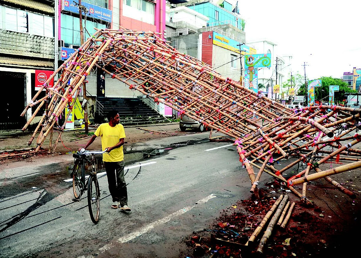 A man walks past a makeshift bamboo gate uprooted due to strong winds under the
impact of Cyclone Sitrang in Agartala on Tuesday.