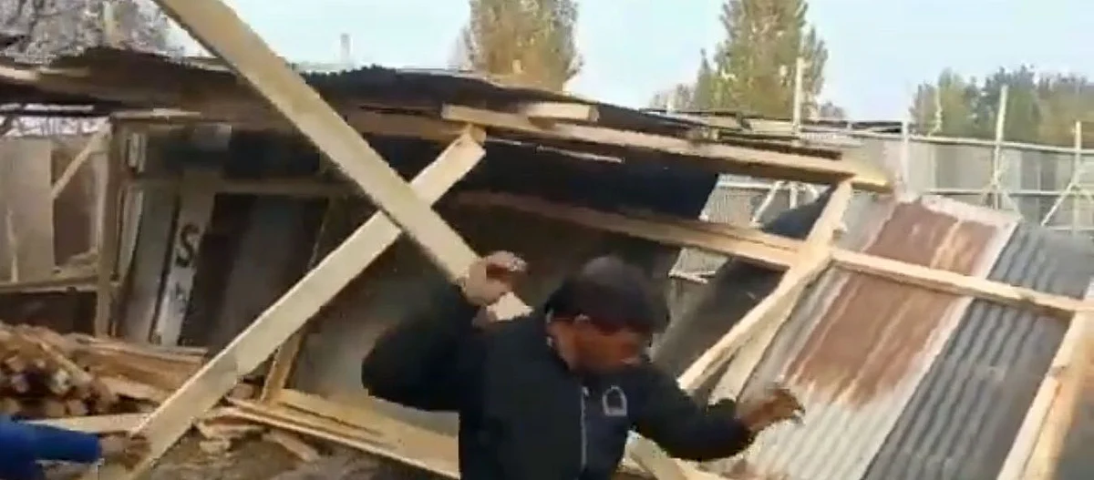 An LCMA worker moves aside after pushing an under-construction structure during a demolition drive.