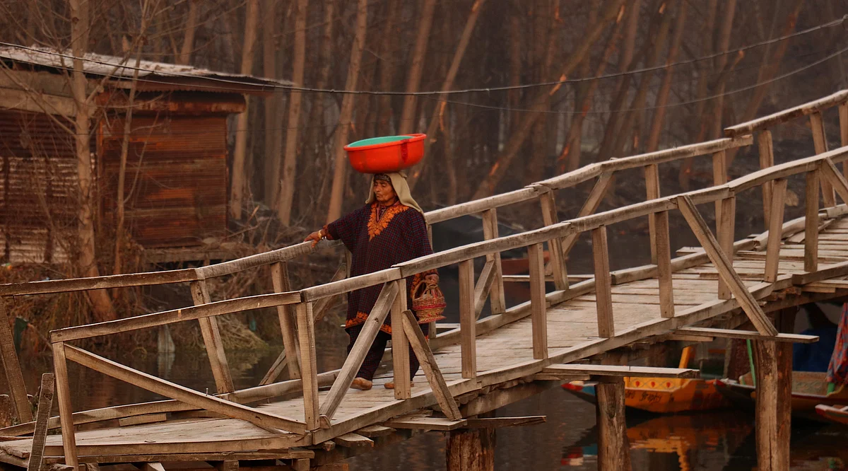 A woman crosses a bridge even as she holds a Kangri in the interiors of Dal Lake on the first day of Chillai Kalan- the forty days of harsh winters in Kashmir- starting from 21st December, every year.