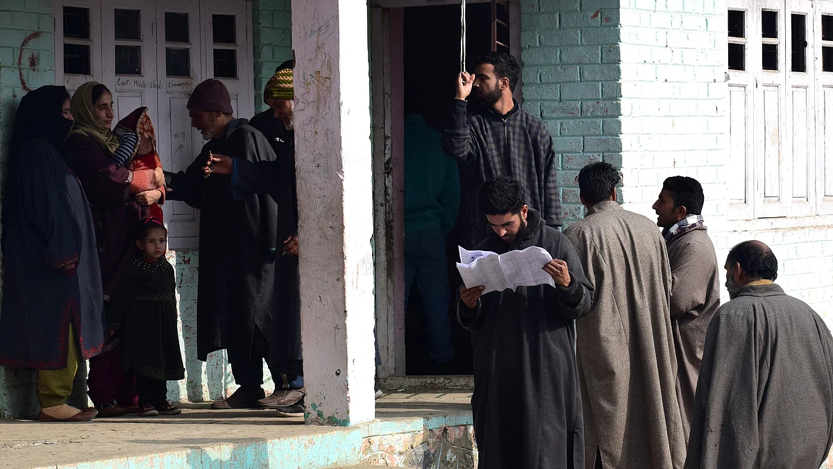 Dressed in Pherans and heavy woolen clothes, women and men waited in long queues while security forces stood guard around the polling booths with semi-automatic rifles and riot gear.