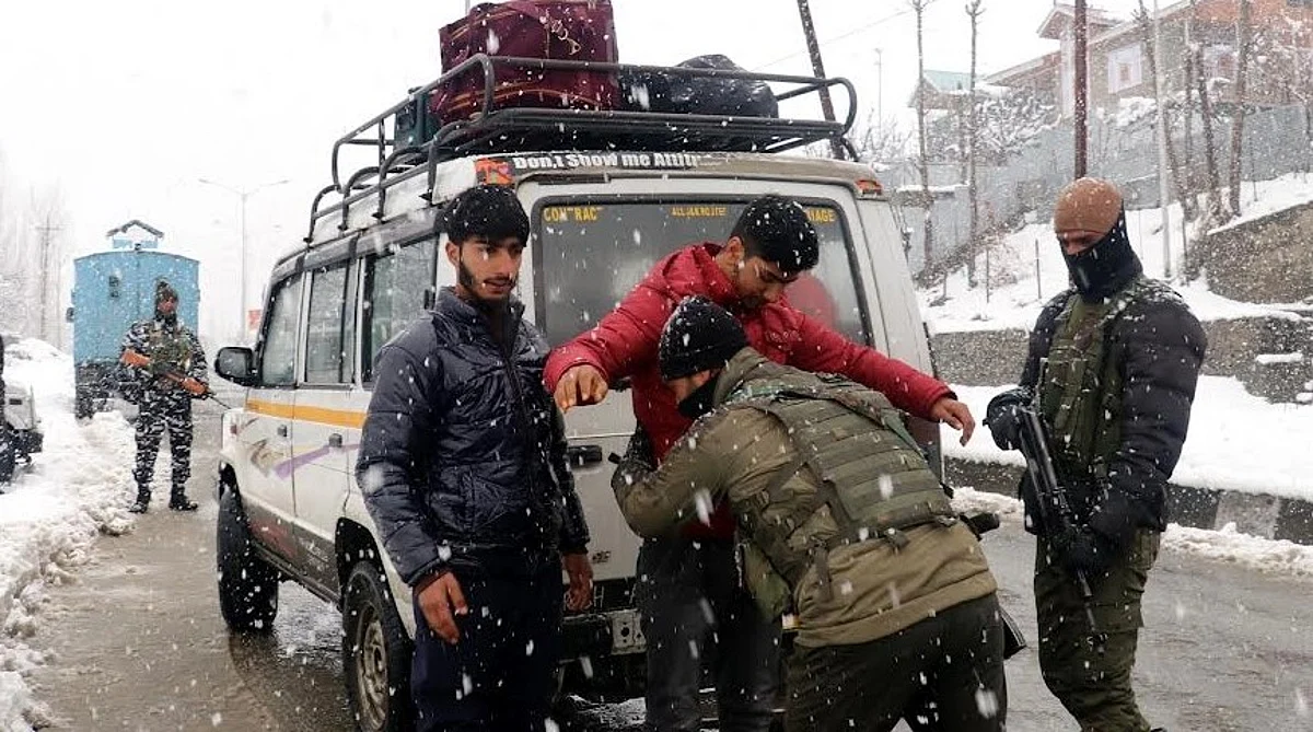 Police personnel frisk passengers along Tangmarg road in north Kashmir's Baramulla amid snow. Security grid has been intensified across Kashmir ahead of R-day.