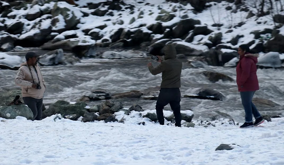 Tourists take snaps as sun shone again after intermittent snowfall turned Sonmarg white.