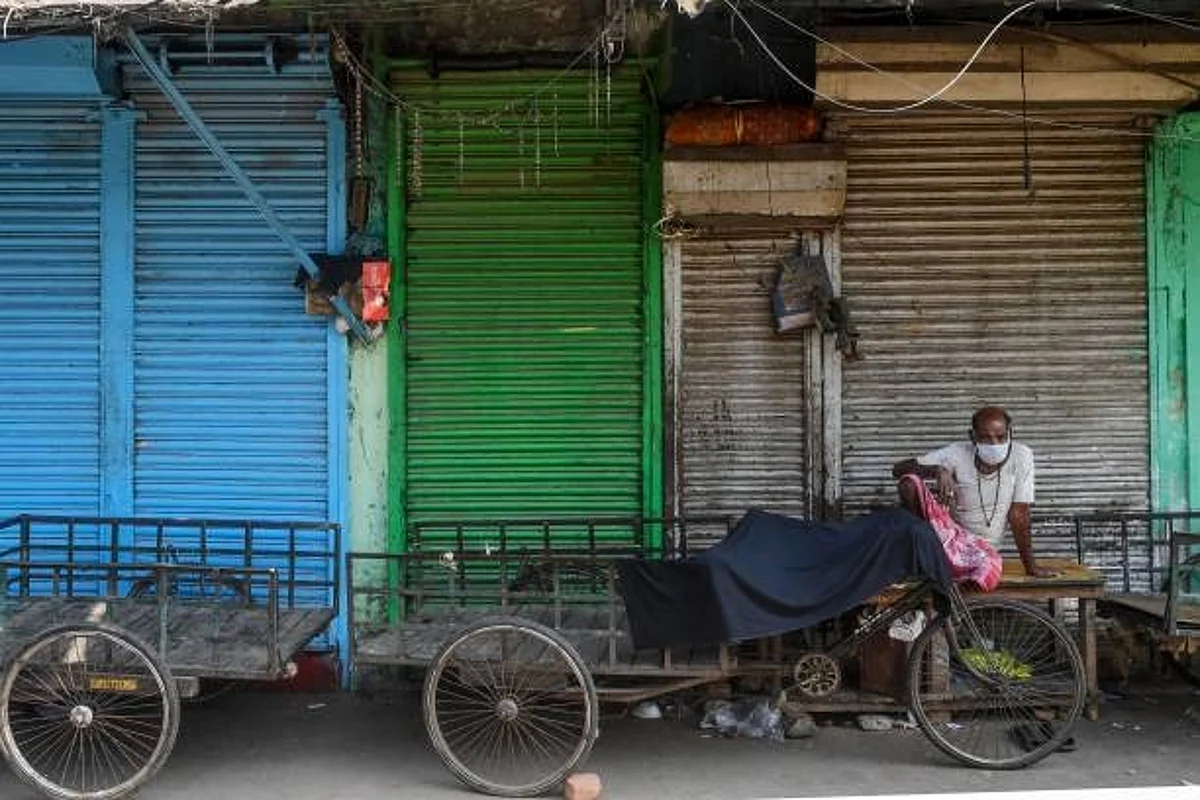 A daily labourer wearing a facemask waits near rickshaws for trucks to come for food commodities at a wholesale market during a 21-day government-imposed nationwide lockdown as a preventive measure against the COVID-19 coronavirus in Kolkata on March 26, 2020. (Photo by Dibyangshu SARKAR / AFP) (Photo by DIBYANGSHU SARKAR/AFP via Getty Images)