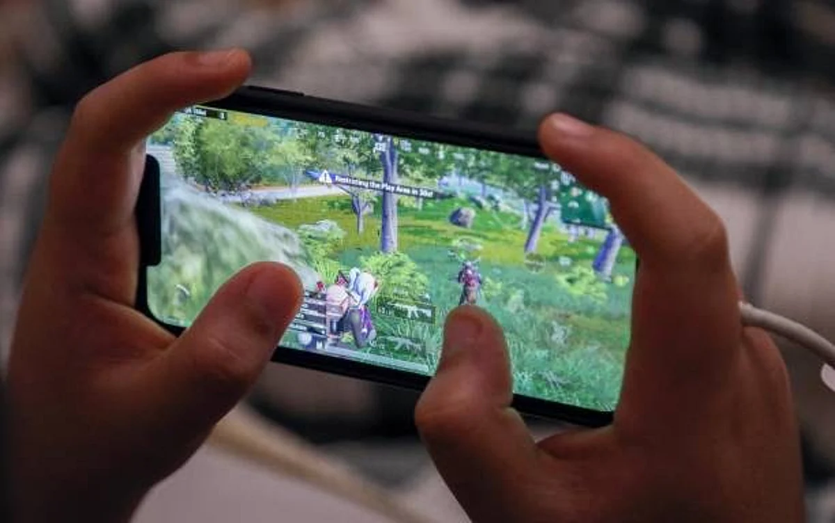 An Iraqi Kurdish youth plays the PUBG video game on his mobile phone in Arbil, the capital of the autonomous Kurdish region in northern Iraq, on May 1, 2021. - The mobile version of the game has become so popular in Iraq that the country's youth have been dubbed the "PUBG generation", as people across the country are spending hours every day on its virtual battleground, socialising via its live chat, playing competitively, or even falling in love. (Photo by SAFIN HAMED / AFP) (Photo by SAFIN HAMED/AFP via Getty Images)