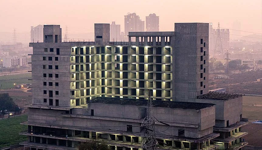 Aerial shot of under construction building shell with lights and skyscrapers in Telangana. Several states in India have eased labour laws and industrial compliance norms to attract more investors.