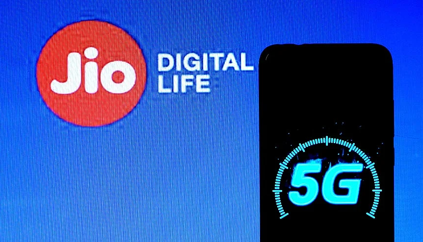 A 5g mobile Spectrum logo displayed on a smartphone with a Jio Digital life logo in the background. Indian companies are investing increasingly in tech infrastructure.