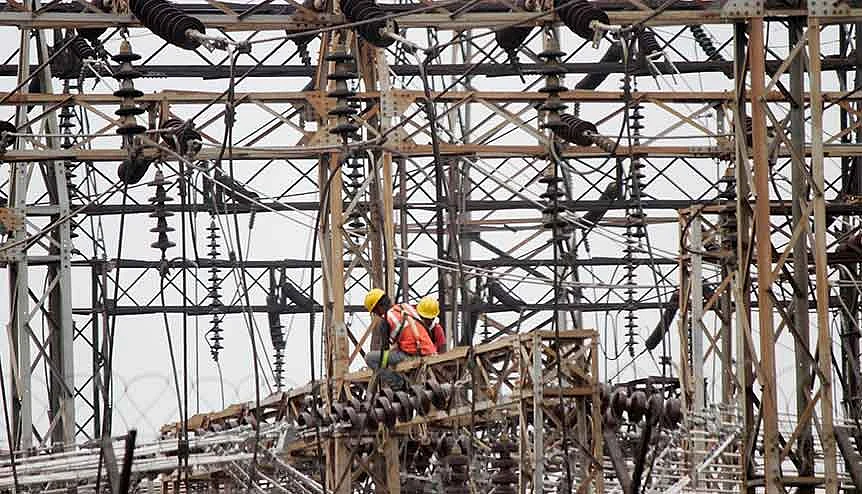 Employees work on electric pylons at a power station near Chhatarpur metro station. The government is keen to utilize and expand on the 60-70 million per year private and public sector smart meter production capacity.