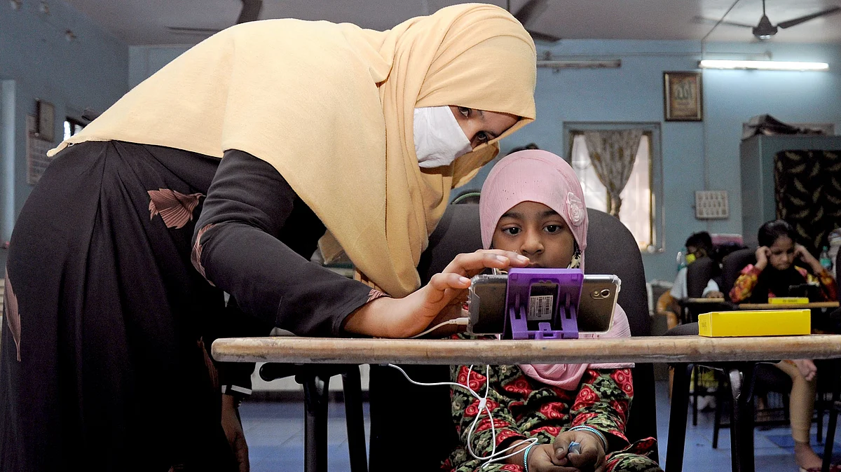 A teacher shows a student how to operate a smartphone at a mobile library. India and many EU countries have sought to distance and safeguard their next generation telecom infrastructure over concerns of privacy, data security and their links with the Chinese government.
