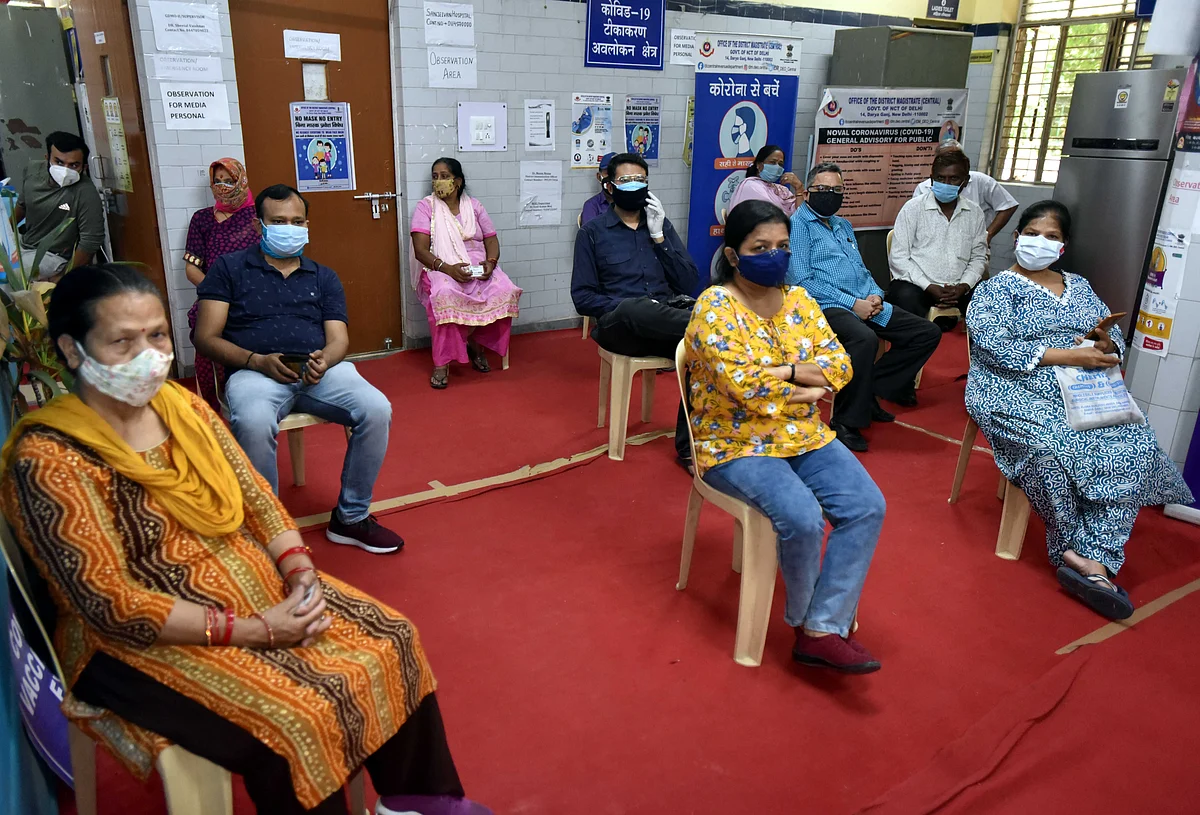 People sit in an observation room after receiving Covaxin vaccine. The risk of further waves of infection remains significant in markets with slow roll-outs of vaccination, including India, but healthcare systems are better prepared after the second wave, which should limit the impact.