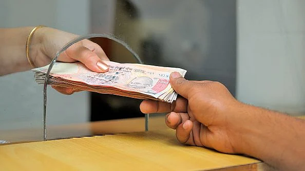 Cash transfer at a counter for stock on banking. The government has given a big boost to e-payments.