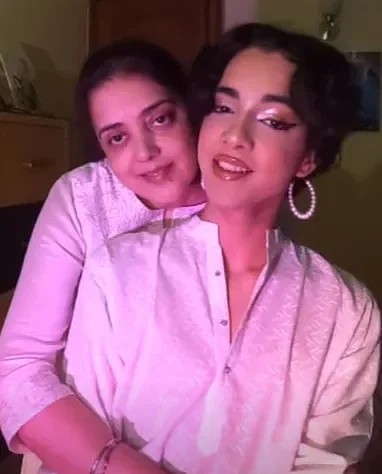 Sanat being hugged by their mother.