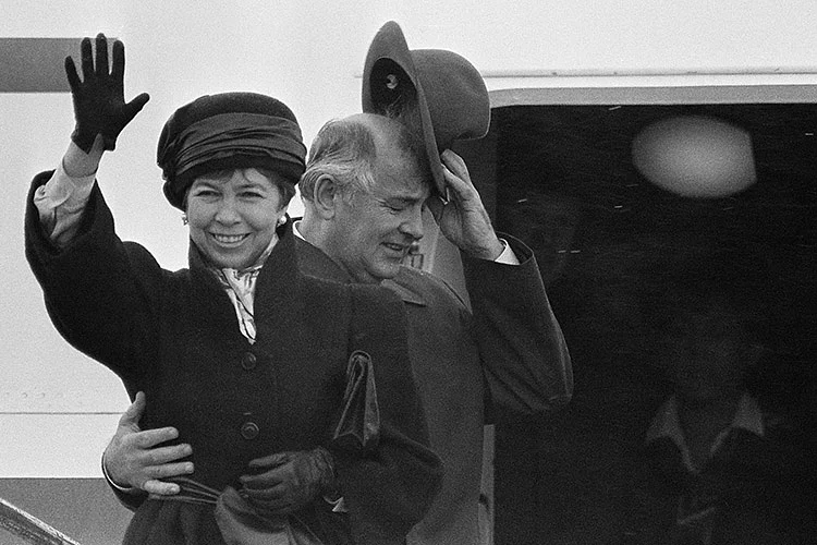 Mikhail Gorbachev holds onto his hat and the waist of his wife Raisa at end of a summit in Reykjavik in Oct.13, 1986.