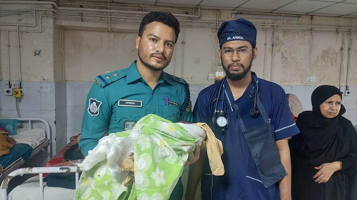 নবজাতককে কোলে নিয়ে আছেন এসআই মোস্তফা কামাল।