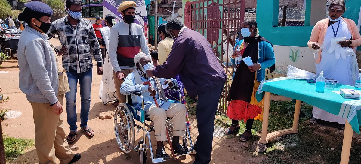 வாக்களிக்க வந்த மாற்று திறனாளிக்கு கரோனா பாதுகாப்பு நடைமுறைகள்