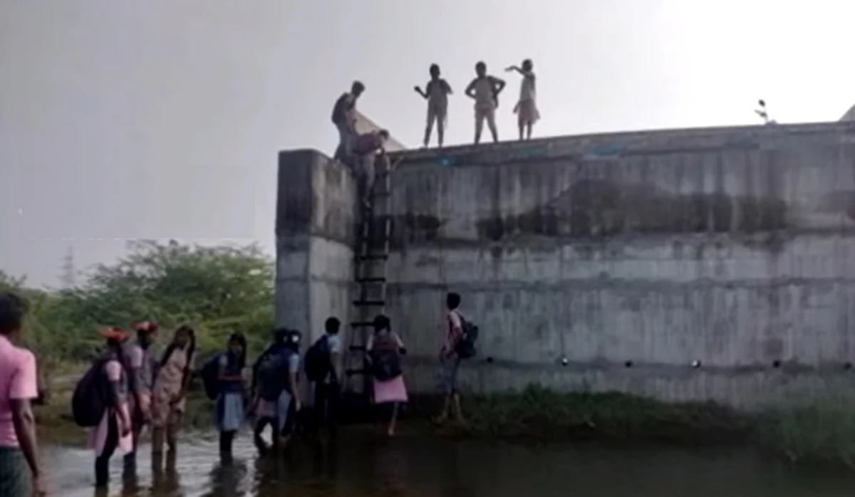 ஆற்றை கடந்து பாலத்தில் ஏறி பள்ளிக்கு செல்லும் மாணவர்கள்: ஆபத்தை உணராமல் பயணம்!