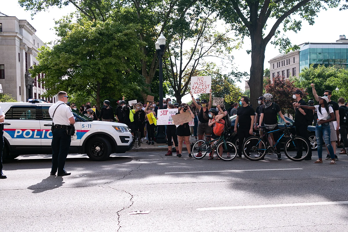 Protesters spill into the street while officers look on during a rally to recall Mayor Andrew Ginther in front of City Hall on June 28.