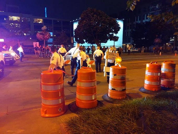 Six police officers remove traffic cones and signs from the intersection at Main and High Street. Officers also removed traffic cones from Rich and High Street before returning to their vehicles.