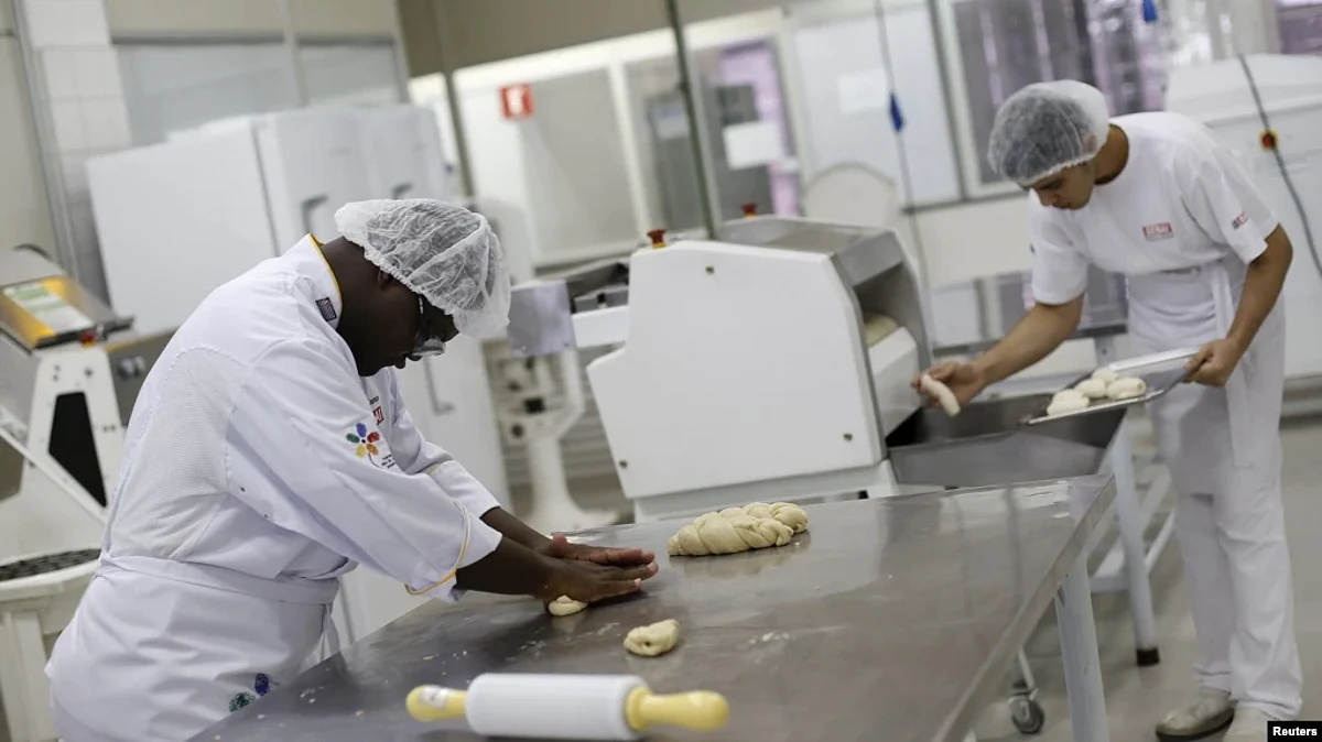 Edmilson Lourenco, left, who has Down syndrome, works as a baker's assistant in Sao Paulo, March 19, 2015. A new hormone treatment for Down syndrome patients showed some cognitive improvement in the small group it was tested on (VOA)