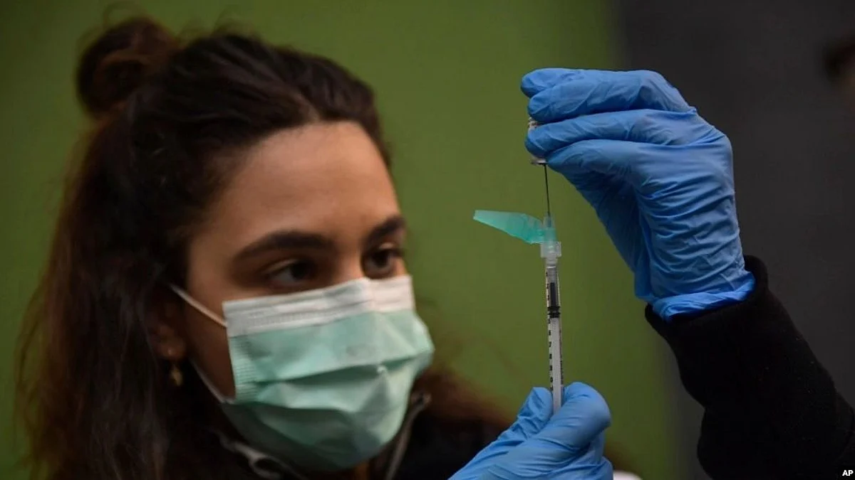 A medical staff member prepares a Pfizer vaccine during a COVID-19 vaccination campaign in Pamplona, northern Spain, on March 16, 2021 (Image Source- VOA)