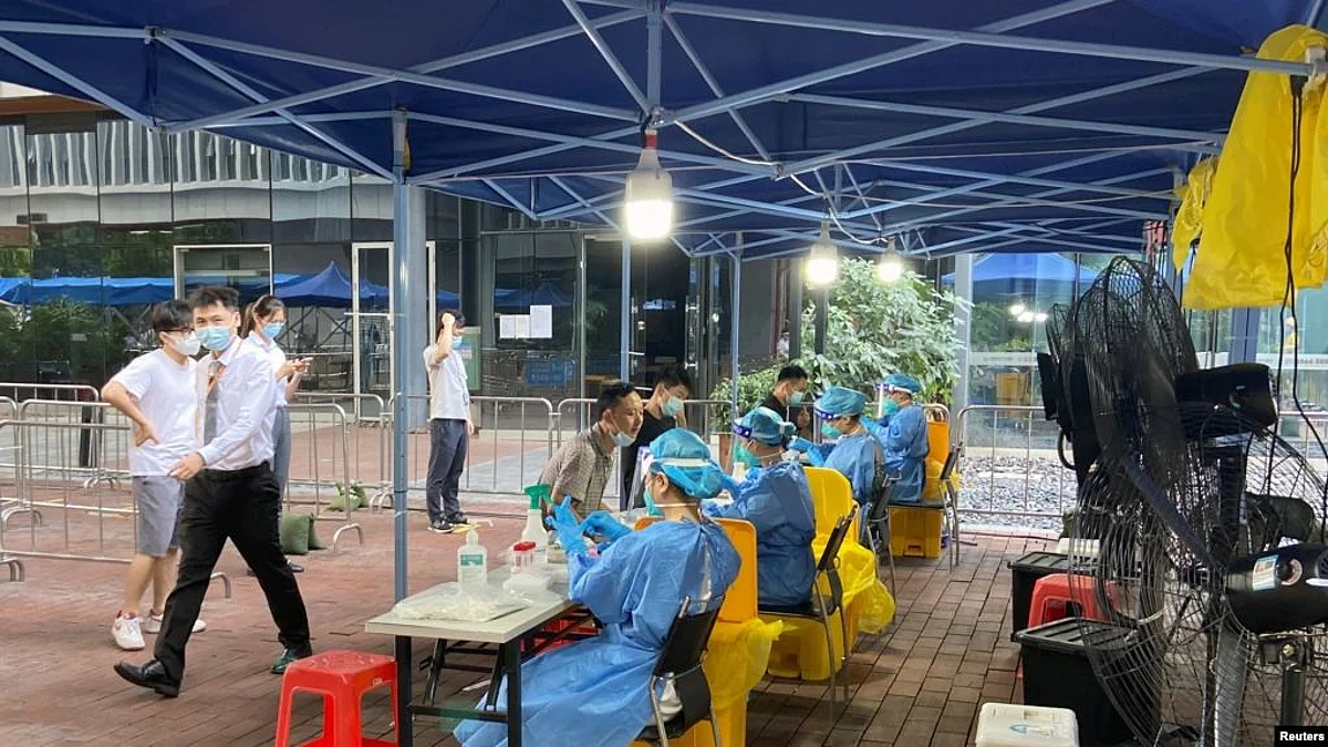 Medical workers in protective suits collect swabs at a nucleic acid testing site at the Software Park in Nanshan district, following the coronavirus disease (COVID-19) outbreak in Shenzhen, China (Image Source- VOA)