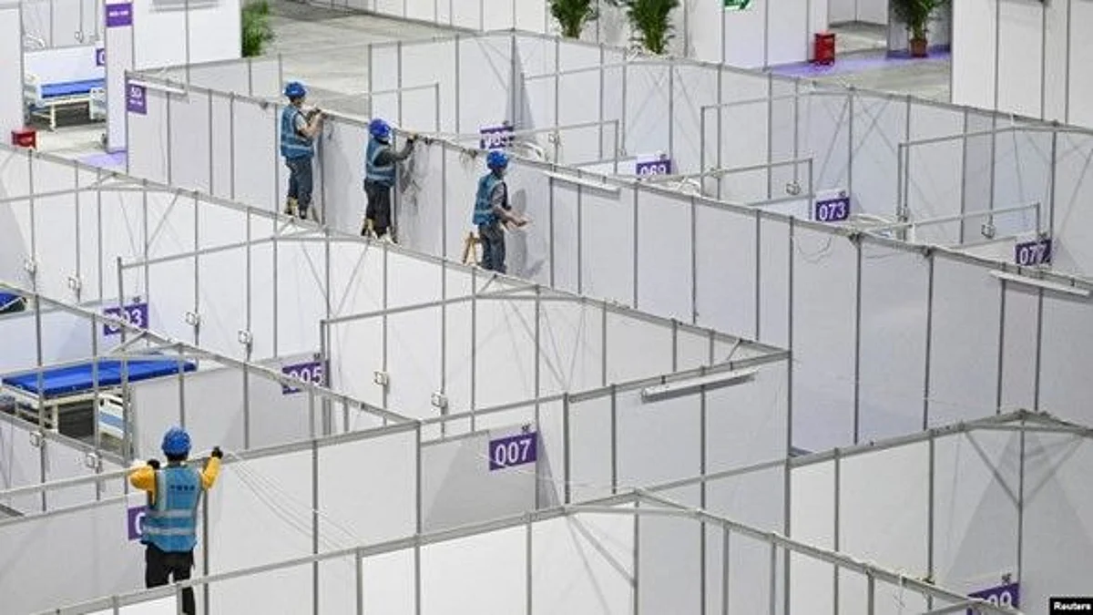 Workers set up equipment inside Pazhou International Convention Exhibition Center to convert it into a makeshift hospital, in Guangzhou, Guangdong province, China, April 10, 2022 (VOA)