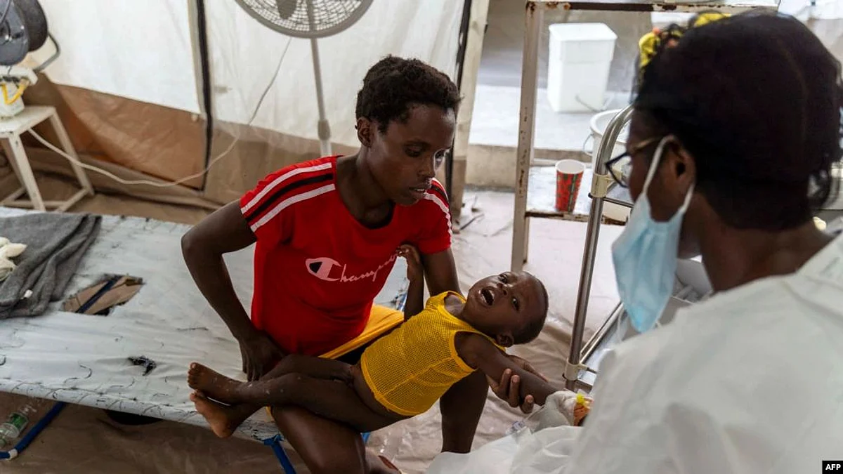 A woman brings a child showing symptoms of cholera to a Doctors Without Borders clinic in Cité Soleil, Oct. 07, 2022. Many of the sick, however, have not been able to get health care because gangs have been blocking access to the fuel patients need to travel for care.