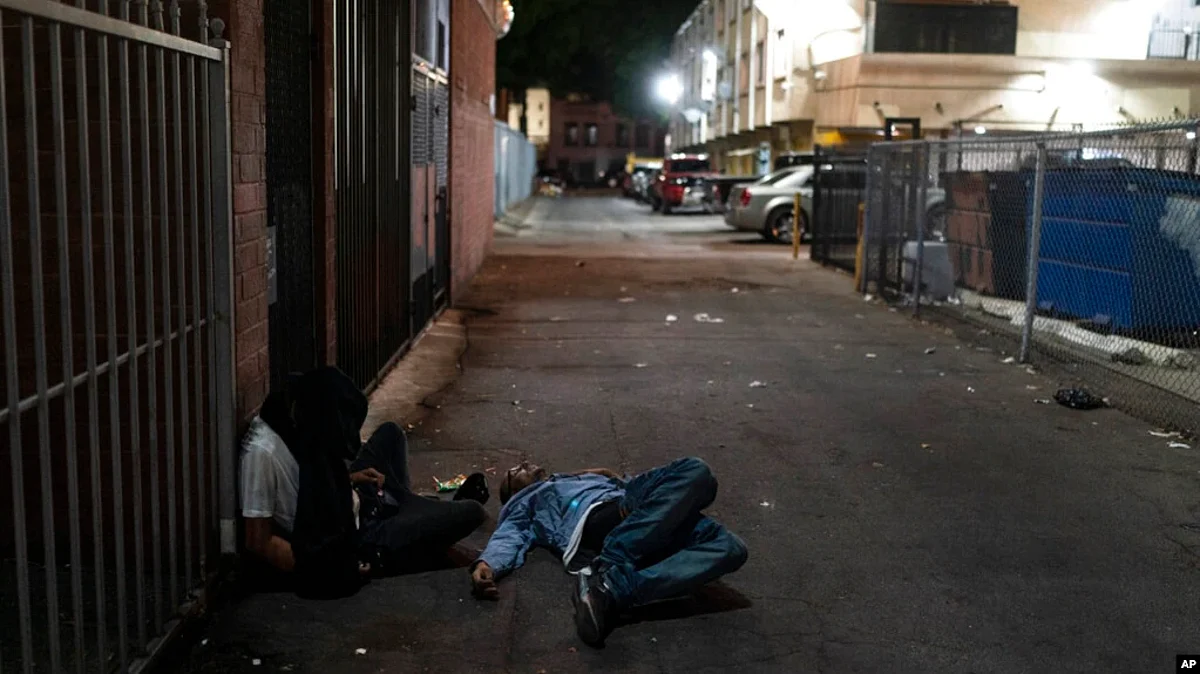 FILE - Two addicts sleep in an alley in Los Angeles, Sept. 21, 2022.