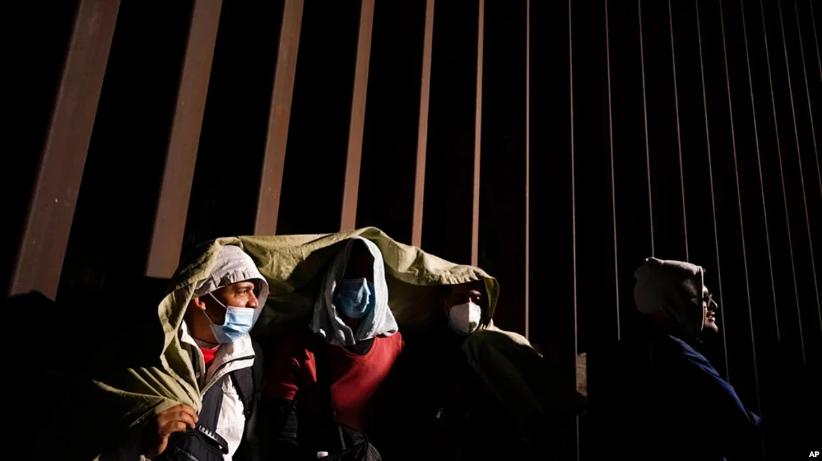 FILE - Four men rest after crossing the U.S.-Mexico border and surrendering to U.S. authorities in Arizona to apply for asylum, Nov. 3, 2022. The U.S. government said Dec. 7, 2022, that it is appealing a court ruling that would otherwise lift asylum restrictions.
