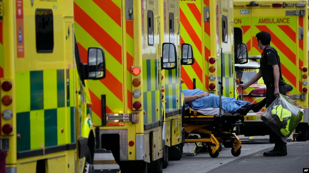 FILE - A patient is pushed on a trolley after arriving in an ambulance outside the Royal London Hospital in the Whitechapel area of east London, Thursday, Jan. 6, 2022.