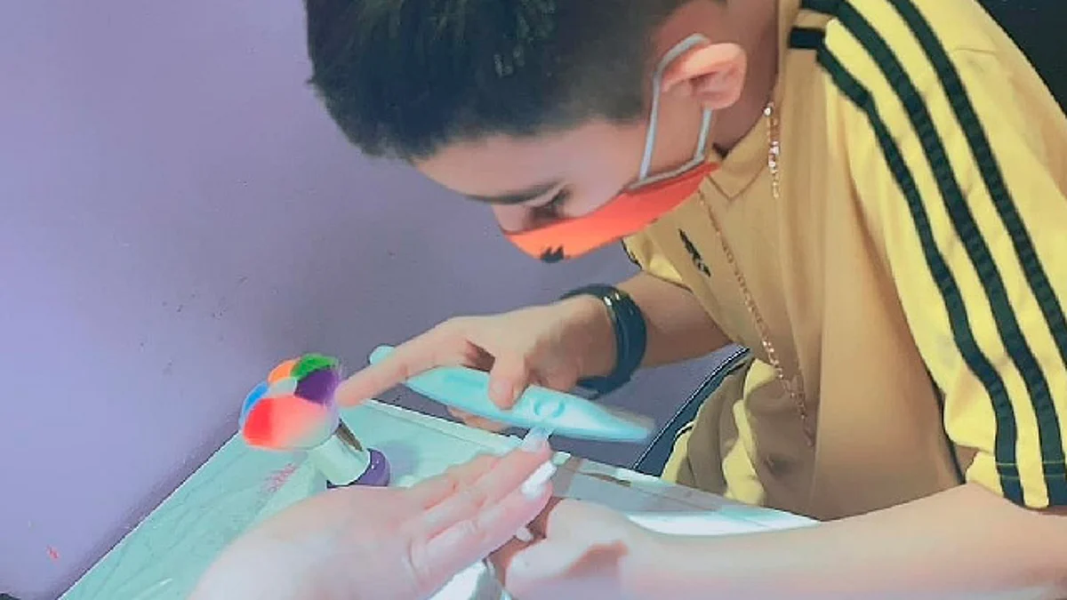 Niño aplica uñas acrílicas para ayudar a pagar operaciones de su hermano