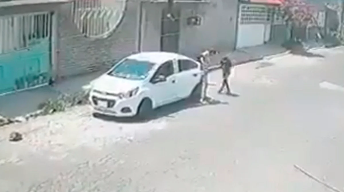 La niña se acerca al auto con una sudadera de capucha que le cubre la cabeza mientras un hombre desciende de la parte trasera del auto, se aprecia en audiovisual