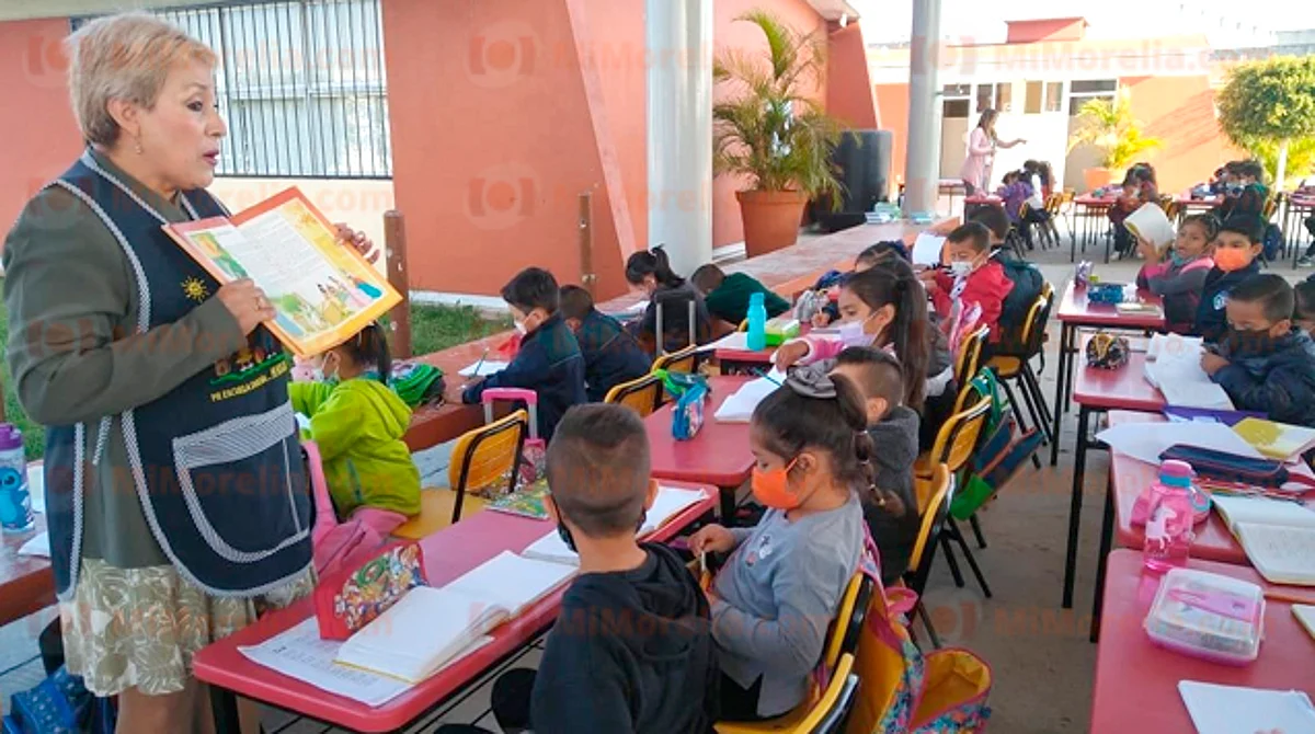 Niños de primer grado toman clases en el patio, toda vez que la escuela quedó dañada