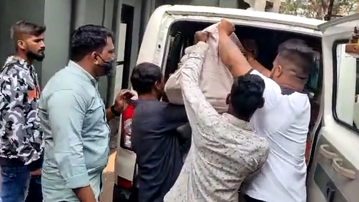 मृतदेह गाडीत ठेवताना कर्मचारी...