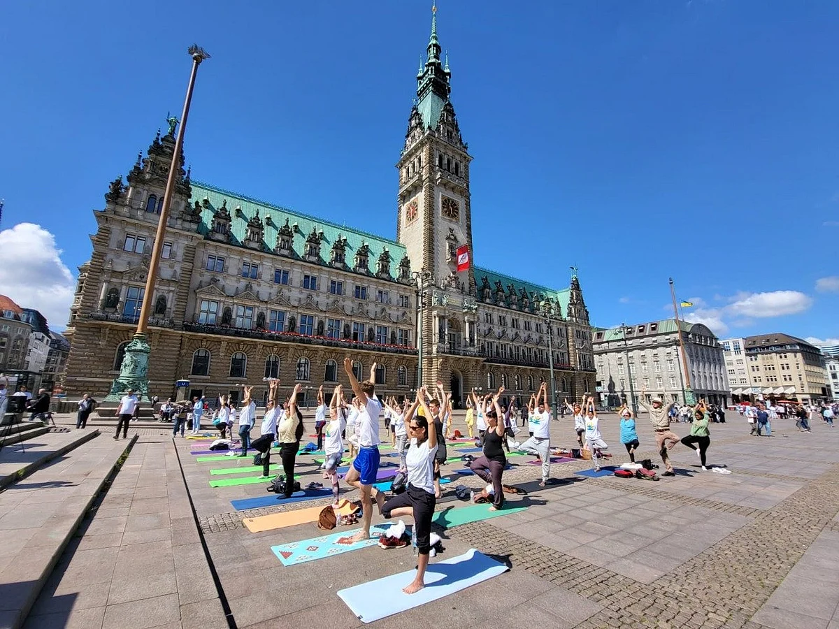 Participants perform Vrikshasana (Tree Pose) at Hamburg Rathaus in Hamburg, Germany.