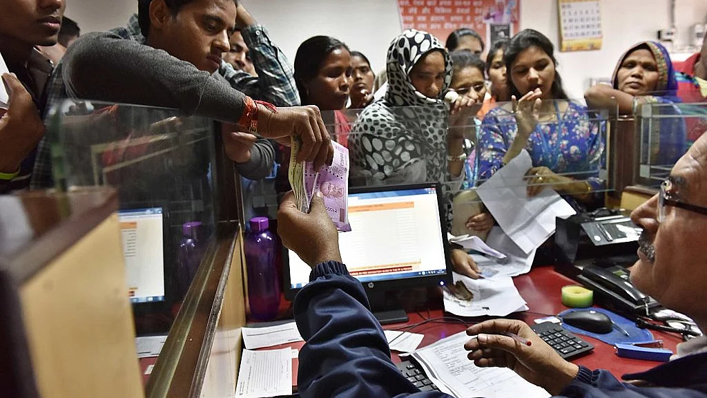 A banker exchanges defunct currency notes at a PNB branch, New Delhi