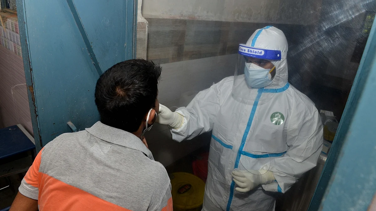 A health worker collects swab samples for rapid antigen testing for COVID-19, in New Delhi on June 23, 2020