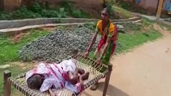 70-yr-old woman drags mother on cot to bank