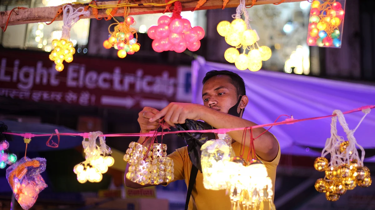 A vendor arranges a variety of colourful decorative lamps, Bhagirath Place, Delhi